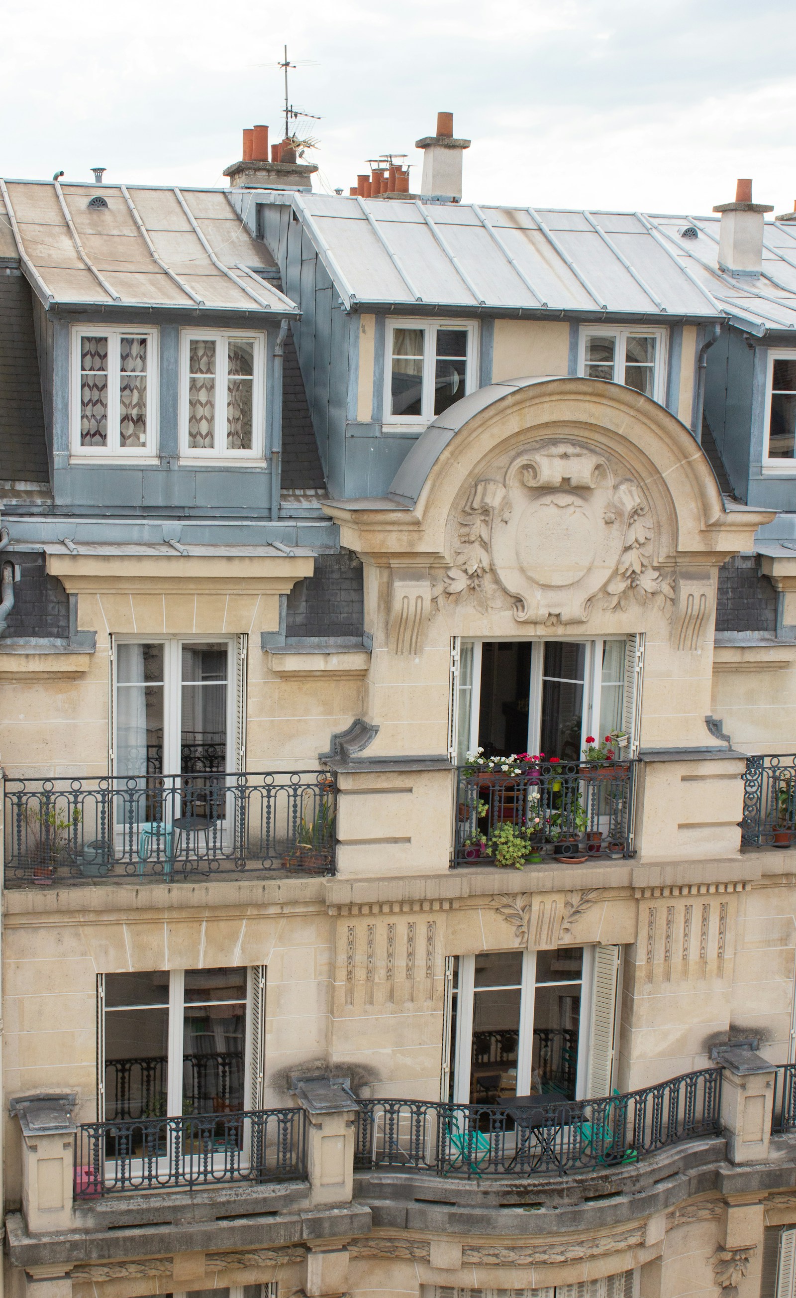 Façade haussmannienne parisienne avec balcons en fer forgé sous une lumière douce, atmosphère du 6ᵉ arrondissement.